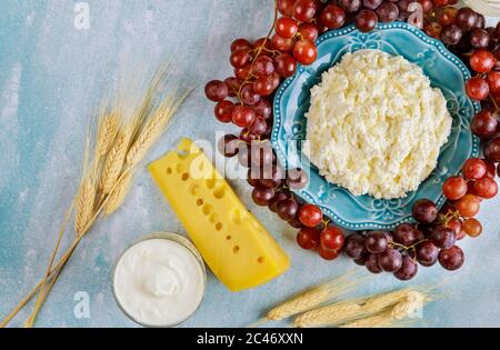 Blauer Teller mit Bauernkäse, Traube und Sauerrahm mit Weizen. Stockfoto