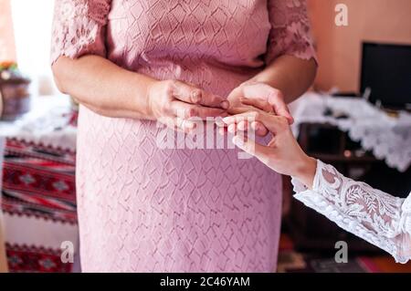 Die Mutter der Braut trägt einen goldenen Ehering am Finger Stockfoto