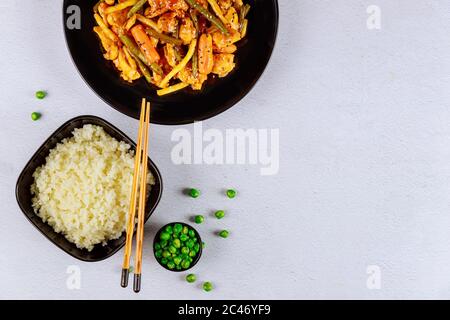 Gemüse mit Huhn und Reis unter Rühren braten. Draufsicht. Stockfoto