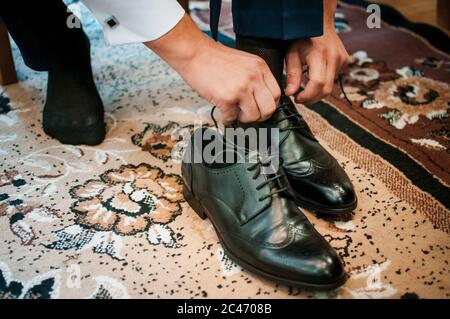 Weißer Mann setzt schwarze Schuhe Stockfoto