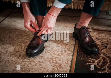 Der weiße Mann legt schwarze Schuhe auf die Beine Stockfoto