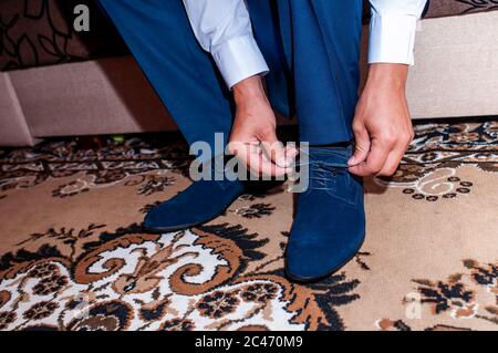 Weißer Mann setzt dunkelblaue Schuhe Stockfoto