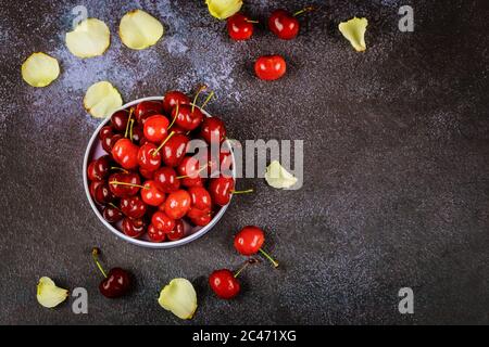 Rote Kirschen in einem Teller auf dunklem Hintergrund. Draufsicht. Stockfoto