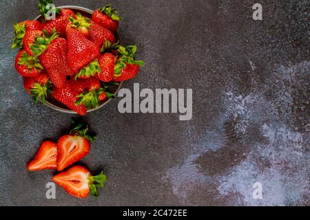 Köstliche frische reife Erdbeeren auf einem Teller auf grauem Hintergrund. Draufsicht. Stockfoto
