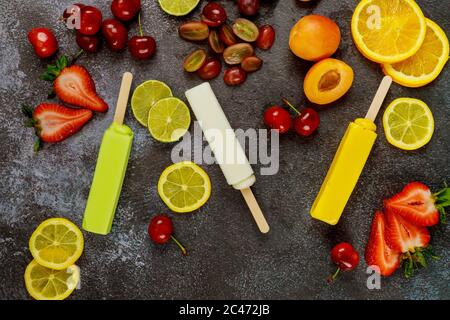 Hausgemachte Orangen-, Kokos- und Limettenpopsicles auf dunklem Hintergrund. Draufsicht. Stockfoto