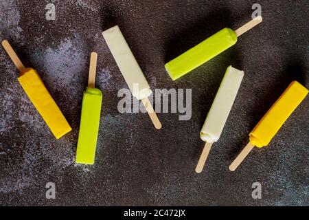 Sechs kalt sortierte Fruchtpopsicles auf dunklem Hintergrund. Stockfoto