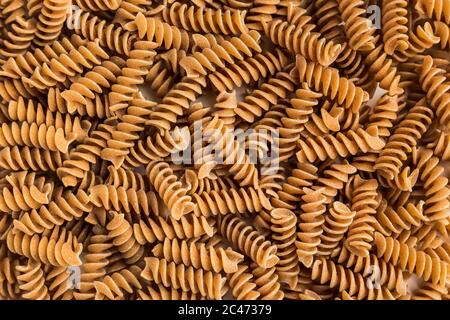 Ein Haufen von Vollkorn Fusilli Pasta auf weißem Hintergrund Stockfoto
