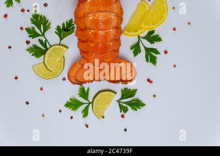 Fertig zum Essen Hummerschwänze mit Zitrone und Petersilie auf weißem Hintergrund.. Draufsicht. Stockfoto