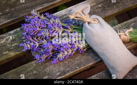 Bund von frischen Lavendelblüten und duftenden Blumen Beutel auf Holz. Stockfoto