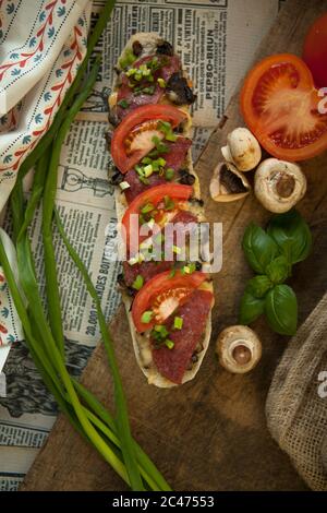 Italienisches Brot, Baguette mit Salami und gelbem Käse in Papier eingewickelt Stockfoto