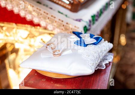 Ein Paar goldene Eheringe auf dem weißen Kissen Stockfoto