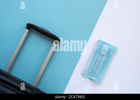Horizontales Farbbild mit einer Ansicht von oben auf einem Reisenden Zubehör auf einem Sommerurlaub 2020 mit dem Coronavirus auf einem blau-weißen Hintergrund. Stockfoto