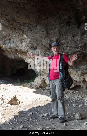Naturfotograf mit Digitalkamera. Er ist in einer Grotte. Stockfoto