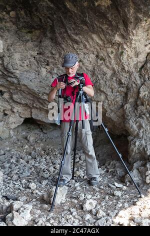 Naturfotograf mit Digitalkamera. Er ist in einer Grotte. Stockfoto
