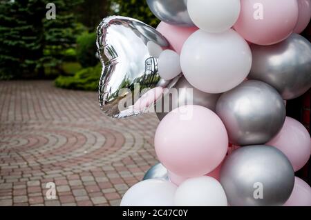 Pinkgraue und weiße aufblasbare Luftballons im Innenhof Stockfoto