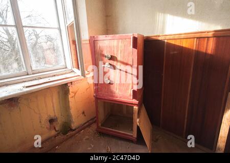 Safe aus rotem Stahl im verlassenen Zimmer Stockfoto