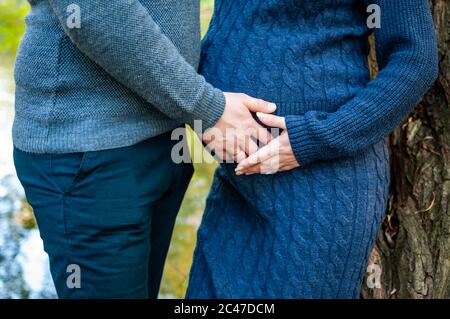 Schwangere Frau und Mann halten die Hände in Form eines Herzens Stockfoto