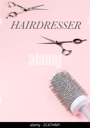 Mehrere Friseurtools. Schere und Haarbürste. Auf einem rosa Hintergrund. Stockfoto