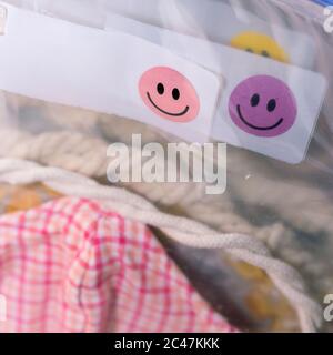 Deluxe Stoff Maske in Plastiktüte Nahaufnahme auf Smiley Gesicht ausgeblasen Hintergrund und Vordergrund Stockfoto