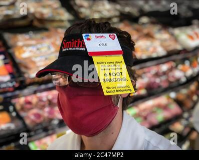 Kalispell, Montana, USA. Juni 2020. Ein Lebensmittelhändler bei Smith's in Kalispell, Montana, wo ein Schild auf seinem Visier sagt, dass Smith sich um Sie und mich kümmert, also bitte halten Sie 6 Fuß Abstand für soziale Distanzierung. Kredit: Kent Meireis/ZUMA Wire/Alamy Live Nachrichten Stockfoto