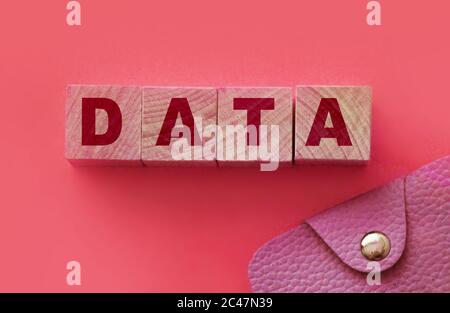 Datenwort auf Holzblöcken mit Buchstaben und rosa Ledertasche. Datenschutzkonzept Stockfoto
