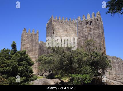 Die Zinnen des mittelalterlichen Guimaraes Castle. Guimaraes, Minho Region im Norden Portugals. UNESCO-Weltkulturerbe. Stockfoto