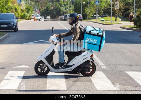 Almaty, Kasachstan - 13. Juni 2020: Wolt-Kurier mit Motorroller auf der Almaty-Stadtstraße Stockfoto