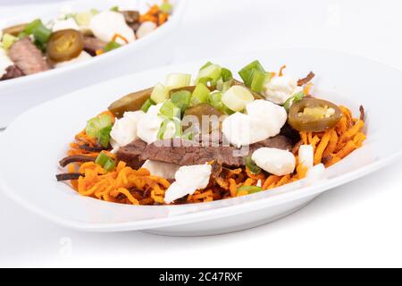 Süßkartoffel Jalapeno und Rindfleisch Steak poutine kanadische Gericht mit grünem Oignon gekrönt Stockfoto