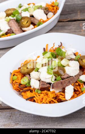 Süßkartoffel Jalapeno und Rindfleisch Steak poutine kanadische Gericht mit grünem Oignon gekrönt Stockfoto