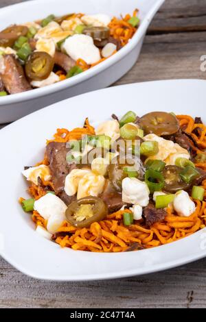 Süßkartoffel Jalapeno und Rindfleisch Steak poutine kanadische Gericht mit grünem Oignon gekrönt Stockfoto