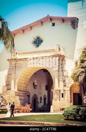 Beachten Sie die spanische Inschrift über dem Eingang des Santa Barbara County Courthouse durch den Säulenbogen am Eingangsweg von Braut und Bräutigam Stockfoto