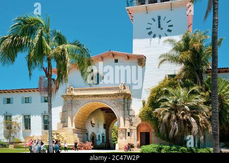 Menschen um das Wahrzeichen, Santa Barbara County Courthouse Eingang und Blick durch den Säulenbogen Eingang zu den Gärten in Santa Barbara, CA, Stockfoto