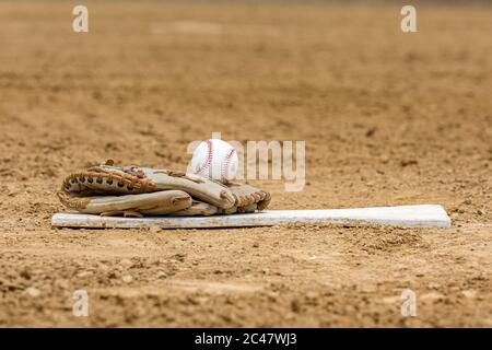 Baseballhandschuh, Ball auf Pitching Hügel. Konzept der Wiedereröffnung der amerikanischen Sportsaison, Erholungsaktivitäten während der Covid-19 Coronavirus-Pandemie Stockfoto