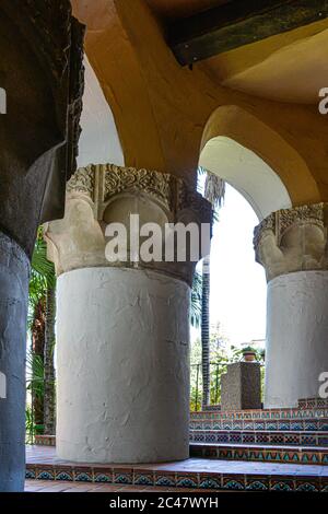 Wendeltreppe aus dekorativen spanischen Fliesen, neben stout Säulen mit Schriftrollen im historischen Santa Barbara County Courthouse, CA Stockfoto