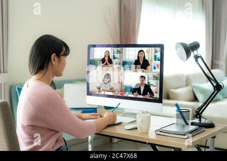 Rückansicht der asiatischen Geschäftsfrau, die mit ihren Kollegen über den Plan in der Videokonferenz spricht. Multiethnisches Business Team, das Computer für ein Online-Treffen verwendet Stockfoto