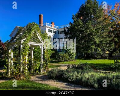 Außenansicht des Goodwin Mansion im Federalist-Stil und Landschaftsgarten im Herbst. Erbaut 1811, griechische Revival Details. Der Herbst hinterlässt einen leuchtend blauen Himmel. Stockfoto