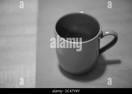 Nahaufnahme einer leeren Tasse in Graustufen Stockfoto