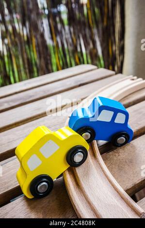 Nahaufnahme von Spielzeugautos aus Holz in der Nähe einer Holzspur Stockfoto