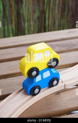 Nahaufnahme von Spielzeugautos aus Holz in der Nähe einer Holzspur Stockfoto