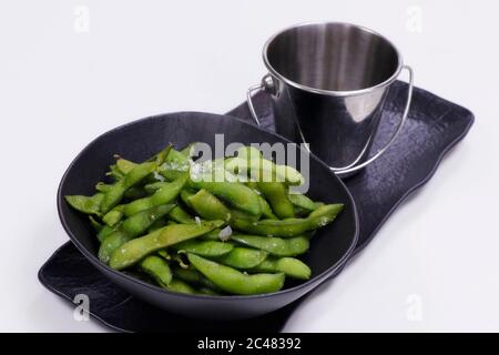 Gekochte grüne Sojabohnen in der Hülse, die als Edamame bekannt ist Stockfoto