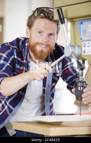 Arbeiter senken Bohrer auf Maschine Stockfoto