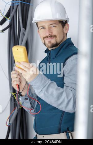 Elektriker die Messung der Spannung der Kabel an der Decke im Innenbereich Stockfoto