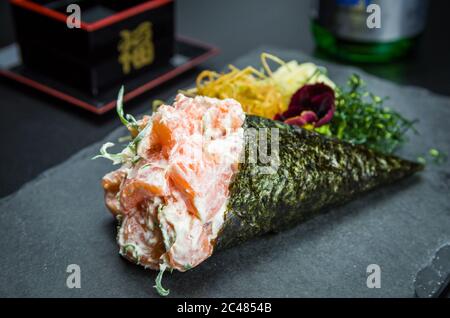 Sushi. Traditionelle japanische Küche, Premium Lachs Temaki mit Frischkäse in einem eleganten Ambiente. Stockfoto