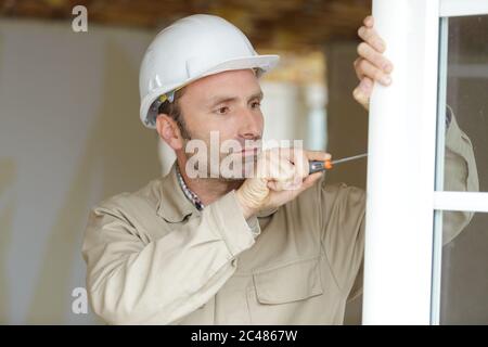 Ein reifer Handwerker Reparaturfenster Stockfoto