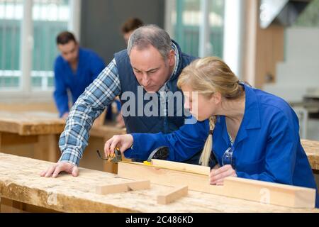 Junge weibliche Schreiner Messung von Holz in der Werkstatt Stockfoto