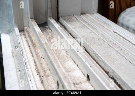 In den Kunststofffensterrahmen stapelten sich schmutziger Staub. Stockfoto