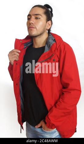 Junger hispanic Mann mit gerafftem Haar fertig Bogen trägt schwarzes T-Shirt und rote Jacke, mit einer Hand auf seiner Hosentasche, Blick links auf weißen Rückenausschnitt Stockfoto