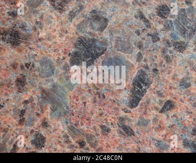 Natürlicher brauner Granit mit schwarzen Spritzern, Nahaufnahme Textur von dunklem Stein. Hintergrund. Stockfoto