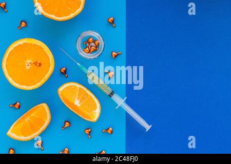 Ampullen und Serum mit Vitamin C.Organic Kosmetik-Konzept. Orange, Mandarine und kosmetische Ampullen auf blauem Hintergrund.Haut Gesichts- und Körperpflege Stockfoto