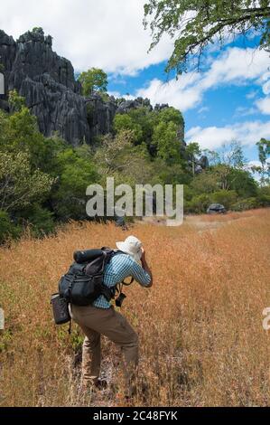 Ein eineingefeilter Landschaftsfotograf, der die Kalksteinfelsen von einem Gestachelfeld um Chillagoe in Queensland, Australien, fotografiert. Stockfoto